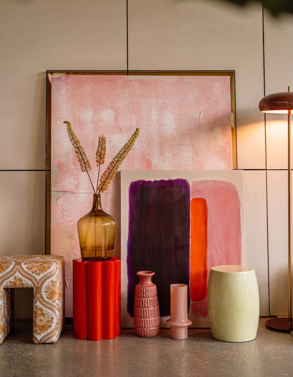 Bijzettafels en vazen op de grond voor roze schilderij