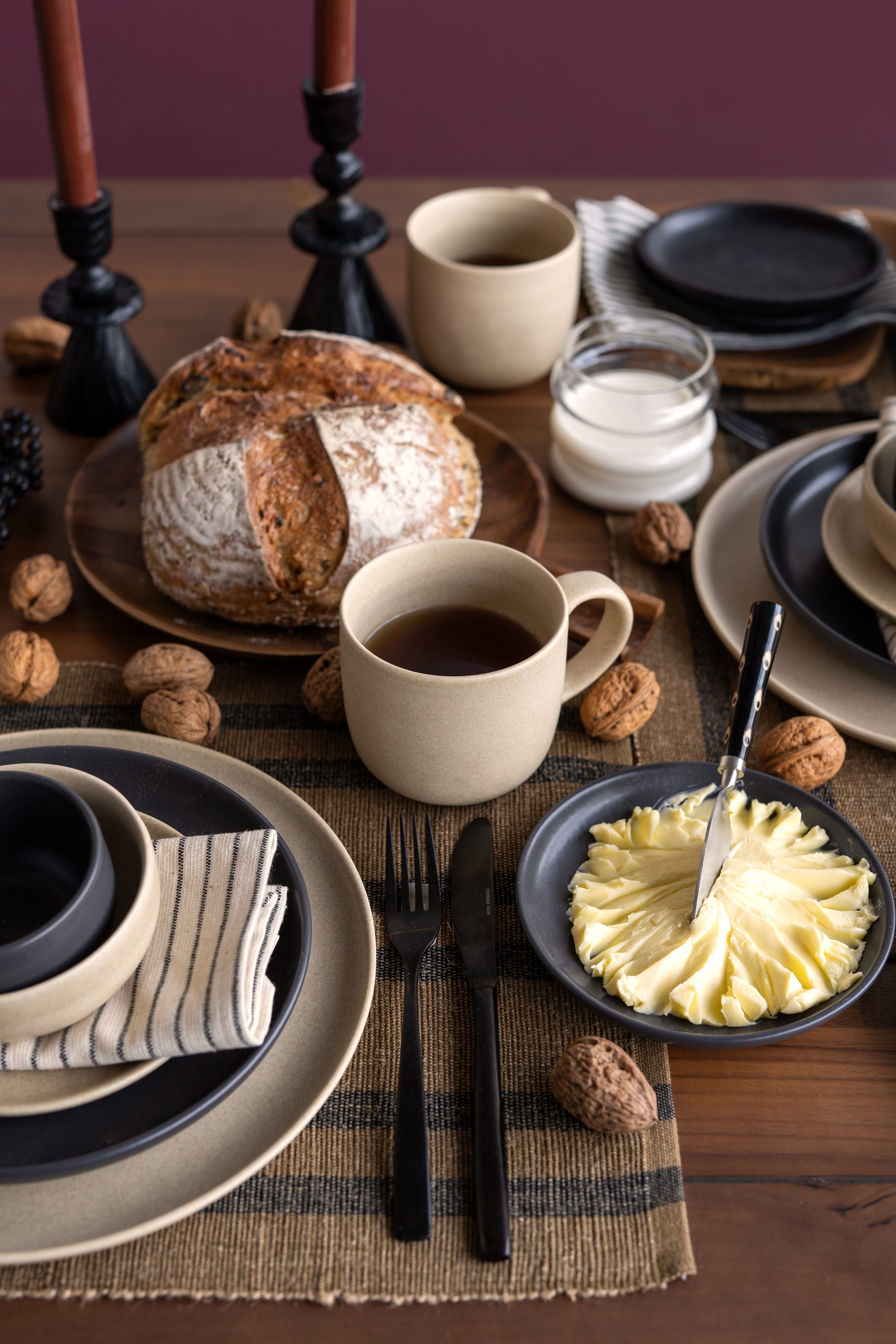 Gedekte tafel met borden, mokken, bestek en verschillende accessoires