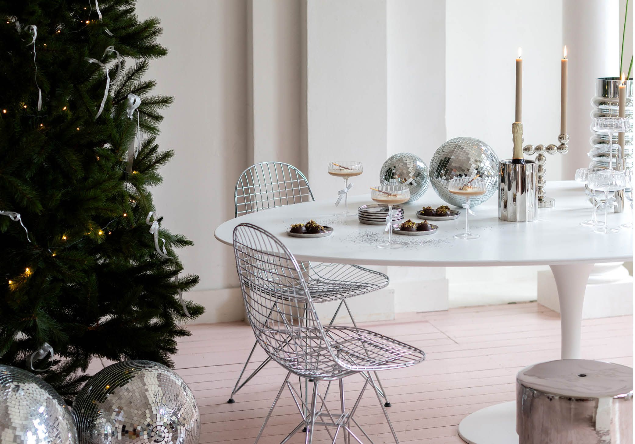 Eetkamer met kerstboom en zilveren accessoires en stoelen